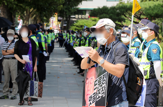 Members of a conservative group hold a press conference near Jongmyo Square Park in central Seoul on Sunday to commemorate Liberation Day. Rallies of all sizes are banned in Seoul due to coronavirus concerns. [NEWS1]
