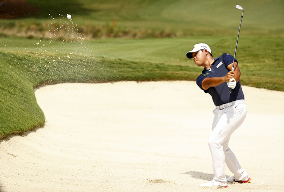 Kim Si-woo takes a shot from a greenside bunker on the 18th hole, the second-playoff hole in a six-way sudden-death playoff, during the final round of the Wyndham Championship at Sedgefield Country Club on Sunday in Greensboro, North Carolina. [GETTY IMAGES]