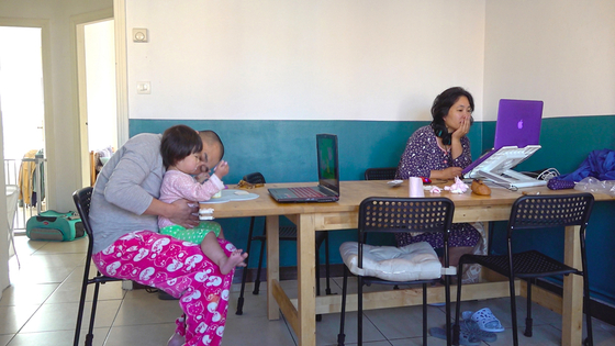 ParkKang, right, studies while her husband takes care of their child. [JINJIN PICTURES]