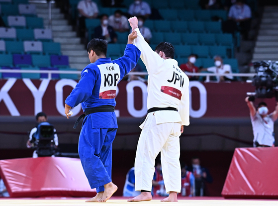 Korean judoka Cho Gu-ham, left, lifts his Japanese opponent’s hand after losing to him in the final match of the men’s 100-kilogram weight class in the Tokyo Olympics. [JOINT PRESS CORPS]