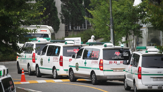 Ambulances transport Covid-19 patients to a dormitory-turned treatment facility for mild cases in Kyonggi University in Suwon, Gyeonggi, on Wednesday. Korea’s daily Covid-19 infections hit a record 2,223 on Wednesday. [YONHAP]
