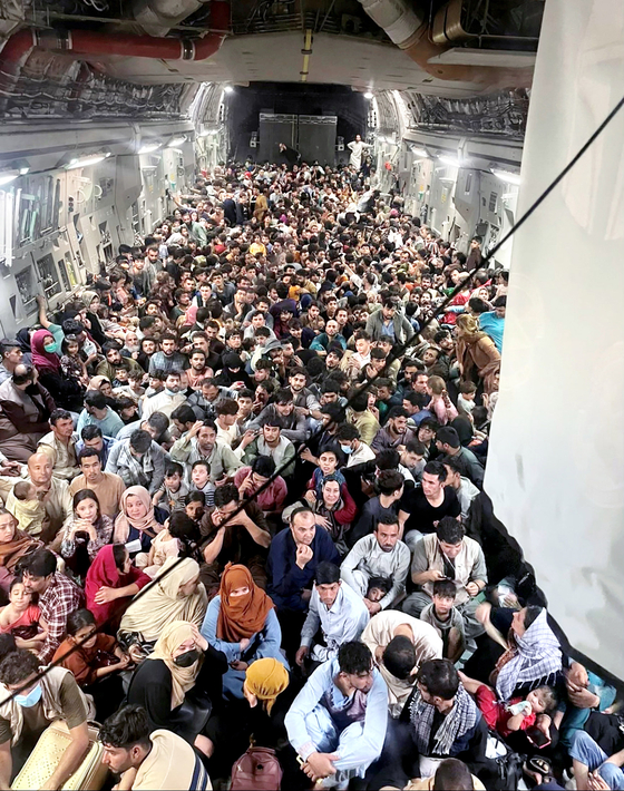 Evacuees are seen inside a U.S. Air Force C-17 Globemaster III transport aircraft, which carried some 640 Afghans to Qatar from Kabul, Afghanistan on Aug.15. [REUTERS/YONHAP]