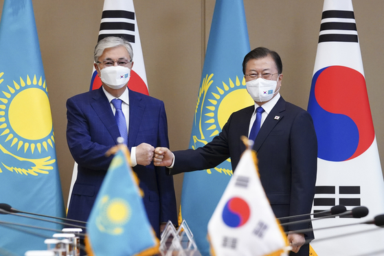 Korean President Moon Jae-in, right, and Kazakh President Kassym-Jomart Tokayev bump fists ahead of their summit at the Blue House in central Seoul Tuesday. [YONHAP]
