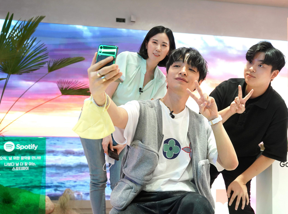 Rapper Simon Dominic takes a picture with customers ordering the Galaxy Z Fold 3 and Galaxy Z Flip 3 on Monday evening at a party held at LG U+'s culture space Daily Teum in southern Seoul. [LG U+]