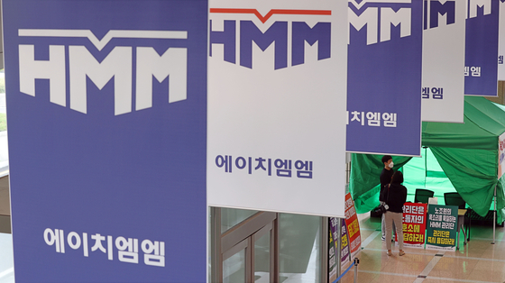 HMM’s union member representing crews on ships stand at the company’s headquarters in central Seoul on Wednesday as a way to demand a higher wage increase for this year. [YONHAP]