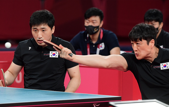 Korea's Kim Young-gun, left, and Kim Jung-gil take on China's Cao Ningning and Guo Xingyuan in the men's team class four to five gold medal match on Thursday. [NEWS1]