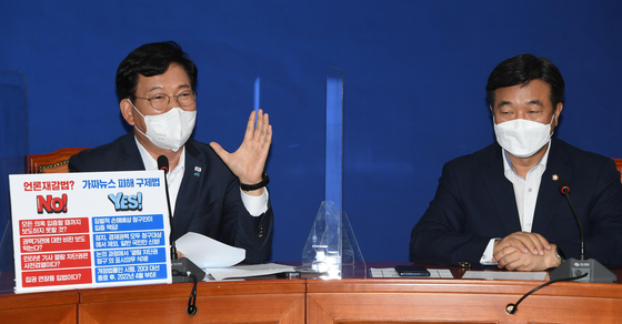  Flanked by ruling Democratic Party (DP) floor leader Yoon Ho-joong, Rep. Song Young-gil, DP leader, speaks about the highly controversial revision to the Media Arbitration Act on August 23. After facing strong opposition at home and even from abroad, the DP took a step back and agreed to discuss the revised bill with the opposition before voting on it on September 27. [KIM KYUNG-ROK]