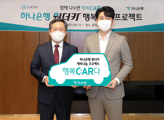 Park Sung-ho, left, CEO of Hana Bank, and Song Min-pyo, CEO of Coactus, pose after attending a ceremony celebrating the bank's donation of two liquified petroleum gas-powered vehicles in Hana's headquarters in Jung District, central Seoul, on Wednesday. [HANA BANK] 