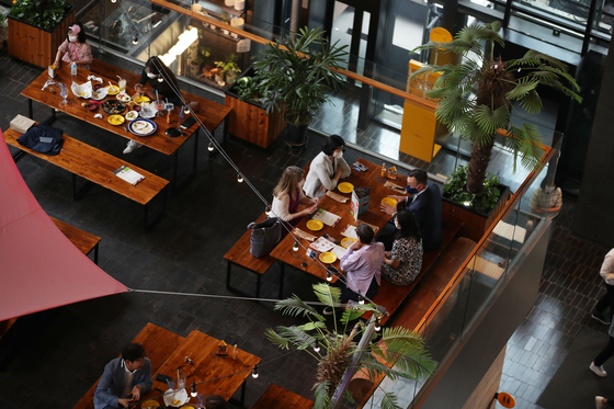  After new social distancing guidelines were announced on Sept. 6, five people eat lunch at the same table. The new rules allow six people, including two fully vaccinated, to have a private gathering. [WOO SANG-JO]