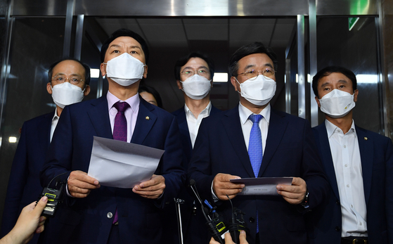 Kim Gi-hyeon, front left, floor leader of the opposition People Power Party, and Yoon Ho-joong, front right, floor leader of the ruling Democratic Party, hold a joint press conference at the National Assembly on Wednesday to announce that they agreed to establish a special committee to discuss a media reform bill. The ruling and opposition leaders announced that the special committee will work on the media revision bill until Dec. 31, 2021, and will consist of 18 members - nine members each from the ruling and opposition parties. [LIM HYUN-DONG]