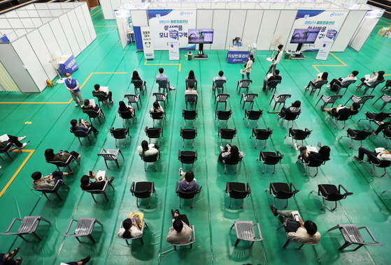 People wait to receive jabs at a Covid-19 vaccination center in Dongdaemun District, eastern Seoul, on Wednesday. Unvaccinated people can reserve for a shot until 6 p.m. Thursday on the Covid-19 reservation website (https://ncvr.kdca.go.kr). [YONHAP]