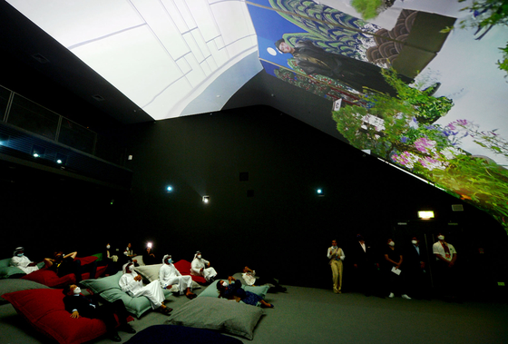 People are lying down in the Vertical Cinema zone of the Korea Pavilion, which has a mega-sized screen and allows people to watch videos. [KOREA TRADE-INVESTMENT PROMOTION AGENCY] 