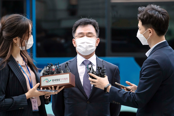 Kim Man-bae, center, owner of Hwacheon Daeyu, an asset management company at the heart of the snowballing Daejang-dong land development scandal, speaks to reporters as he arrives for a hearing at Seoul Central District Court in Seocho District, southern Seoul, Thursday. The court later refused to issue an arrest warrant for him. [JOINT PRESS CORPS] 