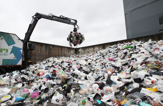 A mountain of waste is piled up at the Suwon Resource Circulation Center in Gyeonggi on Aug. 24, amid a spike in single-use plastics because of the lasting Covid-19 pandemic. The Korean government is enforcing laws that will further cut down use of disposable plastics starting next year. [YONHAP] 