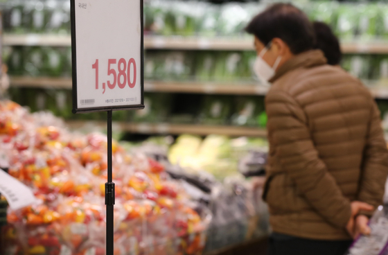 Shoppers pick out fruit at a grocery store in Seoul on Tuesday. Recently, there have been growing concerns about inflation as consumer prices have been rising rapidly. According to the Korea National Council of Consumer Organizations, the average price of 29 necessity goods increased 6.8 percent in the third quarter compared to the same period a year earlier. In the case of eggs, prices have surged 70 percent. Tofu prices rose 16.5 percent, ham 11.3 percent and cooking oil 11.2 percent. Inflation is surfacing as the biggest risk to economic growth as consumers are likely to tighten their spending. [YONHAP]