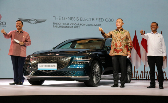 Indonesia's Coordinating Minister for Maritime and Investment Affairs Luhut Binsar Pandjaitan, left, Hyundai Motor Group Chairman Euisun Chung, center, and Indonesia's Investment Minister Bahlil Lahadalia pose for a photo with Hyundai Motor's Genesis G80 electric vehicle at the Jakarta International Expo in Jakarta, Indonesia on Monday. Indonesia selected the Genesis G80 as the official vehicle for the 2022 G-20 Summit in Bali. [YONHAP] 