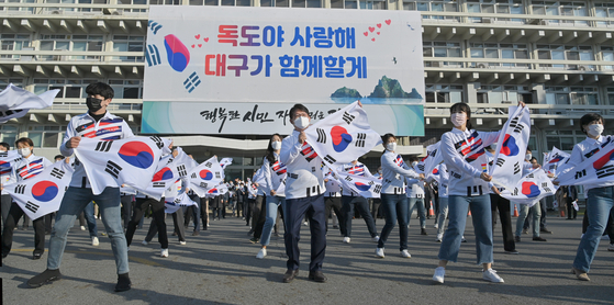 In celebration of Dokdo Day on Monday, Daegu mayor Kwon Young-jin, along with 60 officials and staff members from Daegu Metropolitan Government and North Gyeongsang Provincial Government, perform a flash mob while holding Korean flags in front of Daegu City Hall. This year’s Dokdo Day commemorates the 121st year since King Gojong, Korea’s last king, declared sovereignty over the Dokdo islets on Oct. 25, 1900. [YONHAP]