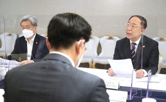 Finance Minister Hong Nam-ki, rigt, during a meeting on real estate at the government complex in Seoul on Wednesday. [YONHAP] 