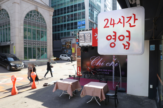 A sign advertising 24-hour operations is displayed at a restaurant in Seocho District, southern Seoul on Friday. The government announced the first phase of the "With Corona" scheme to be implemented for the next four weeks, with the second and third phases to be implemented through January, as part of a broader plan to lift most of the coronavirus restrictions by early next year. Under the new measures, starting next week, people will be allowed to gather in groups of up to 10 in the greater Seoul area and up to 12 in non-metropolitan regions, regardless of vaccination status. [YONHAP]