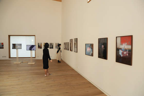 Visitors look at photos exhibited at the Swiss Embassy in Seoul on Oct. 27, which were produced by eight Korean artists inspired by the architecture of the embassy. The exhibition will be open to the public through Nov. 10, before moving to Seoi Gallery in central Seoul, where it will be showcased through Dec. 4. The Swiss Embassy opened its new building in May 2019, returning to the premises that the Swiss Confederation acquired to build its first embassy in Seoul in 1974. The new building was inspired by hanok, or Korean traditional houses. [EMBASSY OF SWITZERLAND IN KOREA]