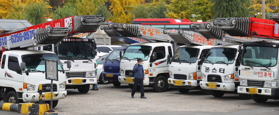 Trucks out of servie at a parking lot at a truck stop in Seoul on Thursday. The shortage of urea solution has forced such commerical trucks off the roads. [YONHAP]