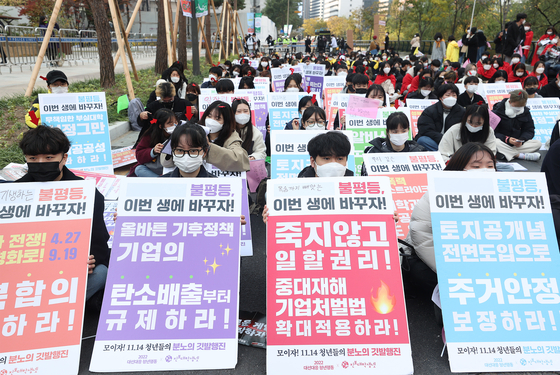 Members of the Youth Action Responding to 2022 Presidential Election group on Sunday stage a rally named “Furious flag march” at Hanbit Square in Jung District, central Seoul, to demand that presidential candidates produce proper pledges for the youth. [YONHAP]