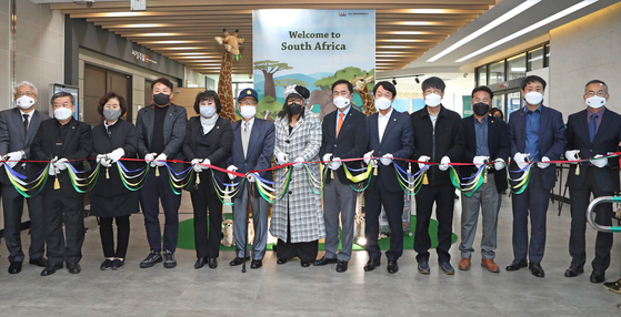 South African Ambassador to Korea Zenani Nosizwe Dlamini, center, Pyeongtaek Mayor Jung Jang-seon, sixth from right, and Gwak Dong-hee, a Korean War veteran and president of the Korean War veterans association in Pyeongtaek, eighth from right, join a tape-cutting ceremony at the Baedari Library in Pyeongtaek on Tuesday to symbolize the start of South African Culture Week. [PARK SANG-MOON]