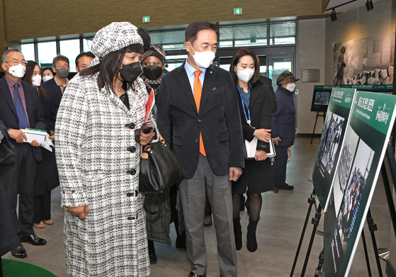 Zenani Nosizwe Dlamini, ambassador of South Africa to Korea, left, and Jung Jang-seon, mayor of Pyeongtaek, examine photos of South African pilots taken during the 1950-53 Korean War at Baedari Library in Pyeongtaek, Gyeonggi, on Tuesday. The photo exhibition is part of South African Culture Week, which kicked off at the library on Tuesday. [PARK SANG-MOON]