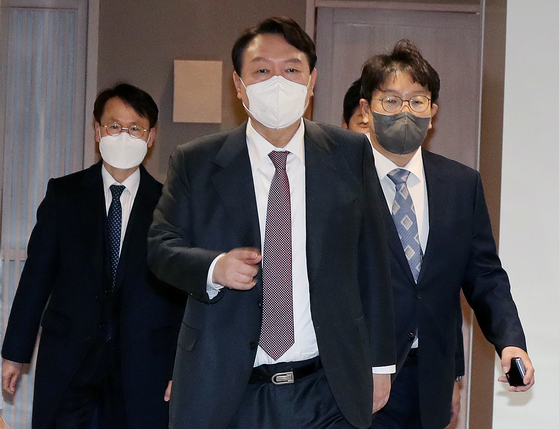 People Power Party presidential candidate Yoon Seok-youl, center, makes his way to a private lunch with the party's new secretary-general, Kwon Seong-dong, right. [YONHAP]