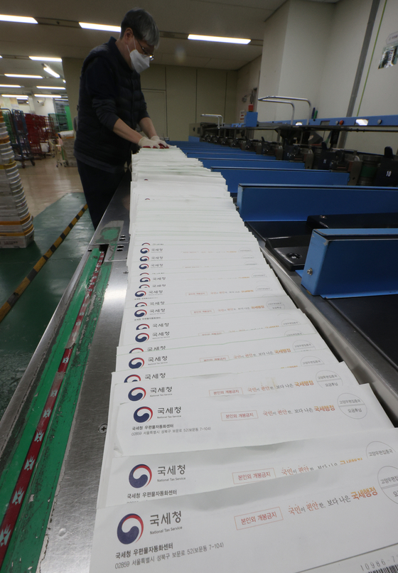 A post office employee in a Gangnam District branch in southern Seoul is sorting out tax bills for homeowners that are to be delivered on Wednesday. This year, the number of people that are expected to receive their bill on the comprehensive real estate holding tax is estimated close to 950,000, up 42 percent year-on-year. The amount they collectively owe increased 216 percent to 5.7 trillion won ($4.8 billion). [YONHAP]
