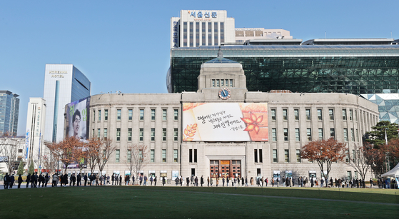 People line up at a Covid-19 testing site at Seoul Plaza in central Seoul Wednesday, after health authorities announced that Korea reached a record high of 4,116 daily cases. [YONHAP] 