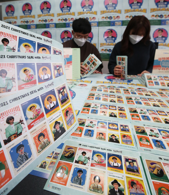 Employees arrange Christmas seals at the Korea National Tuberculosis Association's Gyeonggi office in Suwon on Wednesday. This year's Christmas seals will feature various personas comedian Yoo Jae-suk took on during his TV show "Hangout with Yoo," such as trot singer Yoo San-seul and entertainment agency head Jimmy Yoo. [YONHAP] 