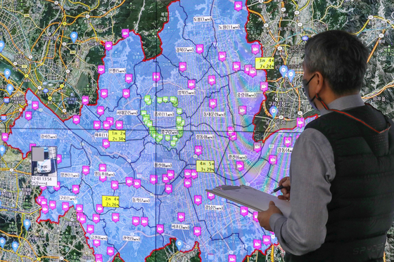 An official from the Seoul city government monitors vehicles without an emission control device at Seoul City Hall in central Seoul on Wednesday. The Ministry of Environment will be cracking down on diesel-fueled vehicles that release high amounts of pollutants from Wednesday to March 31, 2022, in order to reduce fine dust in the air, which gets especially bad during the wintertime. Accordingly, operations of some 860,000 diesel-fueled vehicles that have not installed an emission control device are expected to face limitations as authorities begin crackdowns in around 550 locations across the country. [NEWS1]