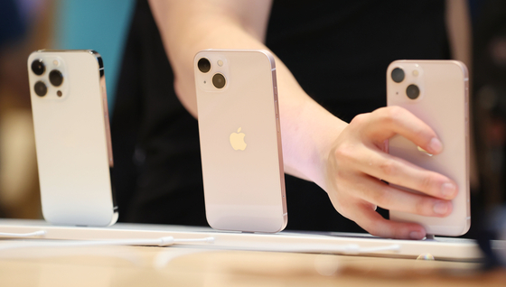 A visitor to the Apple Store in Sinsa-dong, southern Seoul, browses Apple's iPhone 13 series on Oct. 8, the day the manufacturer started selling the models in Korea. [YONHAP]
