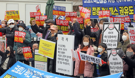 Protestors stage a rally at the government complex in Sejong on Thursday to demand the government withdraw its plan to expand the Covid-19 vaccine pass system to teenagers. [NEWS1]