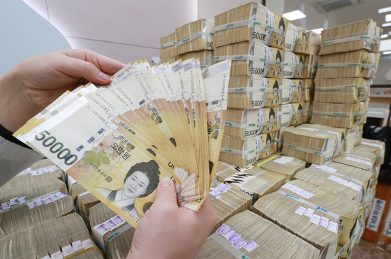 Pile of 50,000 won cash at Hana Bank in Seoul. Thanks to improvement in jobs and economic recovery as well as higher property value, the government continued to enjoy increase in their taxes. However, tax take in October alone fell due to the government suspending taxes on small busiensses impacted by Covid-19 until January. [YONHAP] 