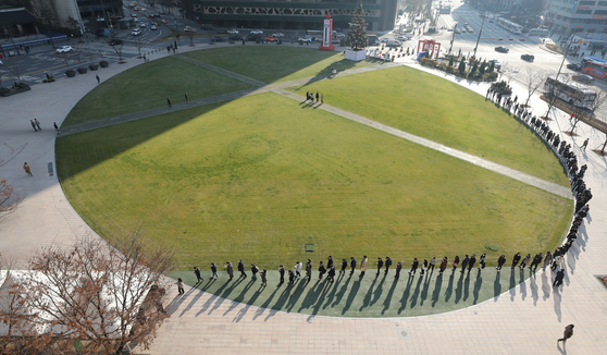 People wait in line to receive tests at a Covid-19 testing station in front of Seoul City Hall in central Seoul on Wednesday. [NEWS1]