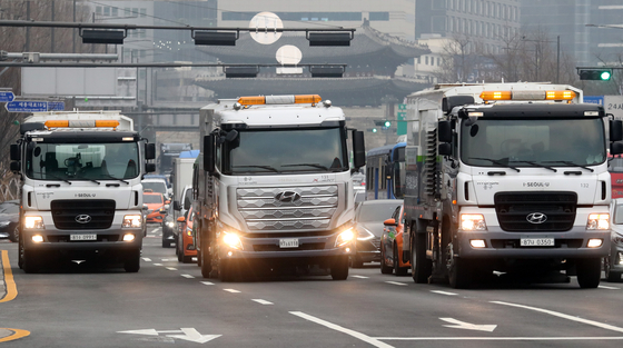 Dust-absorbing trucks suck in dust as they drive down a road in Jongno District, central Seoul, Thursday, as part of an emergency measure to bring down the level of fine dust in the greater Seoul area. The fine dust levels in Seoul Thursday recorded 75 micrograms per cubic meter for more than two hours, three times the city's average. [NEWS1]