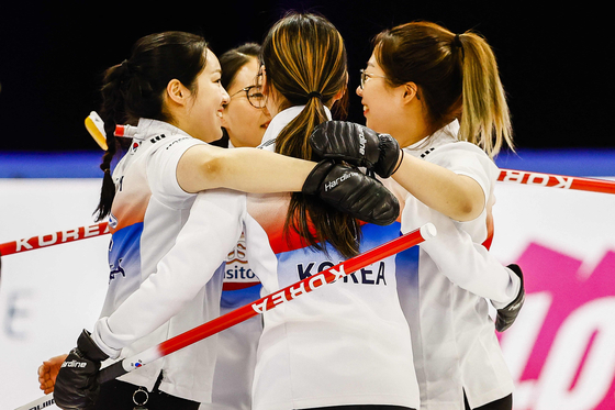 From left, Kim Kyeong-ae, Kim Eun-jung, Kim Cho-hi and Kim Seon-yeong, cheer after winning 8-5 against Latvia on Saturday at the curling qualifying tournament for the 2022 Beijing Winter Olympics in the Elfstedenhal in Leeuwarden, the Netherlands. [AFP/YONHAP]