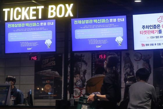 Virus restriction notices are displayed on screens at a cinema in Seoul on Sunday. According to the latest guidelines, cinemas can only stay open until 10 p.m., and moviegoers must sit one seat away from each other. Groups of a maximum of four people can enter together, with the exception of family members whose number is not restricted but must be able to prove their relations through official documents. No food is allowed inside theaters. [YONHAP]