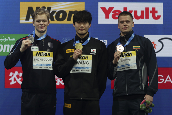 Hwang Sun-woo with gold, center, Aleksandr Sjcjegolev of Russia with silver, left, and Danas Rapsys of Lithuania with bronze stand on the podium after the 200-meter freestyle during the World Swimming Championships in Abu Dhabi, United Arab Emirates, on Friday. [AP/YONHAP]