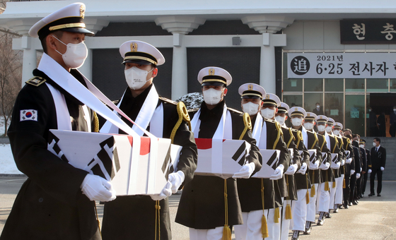 The remains of fallen soldiers in the 1950-53 Korean War are delivered to their final resting place during a ceremony at the Seoul National Cemetery in Dongjak District, southern Seoul, on Monday. [NEWS1]