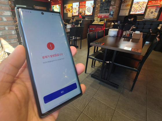 The COOV app crashed due to system traffic during lunch hours on Dec. 13. From Dec. 13, Korea is requiring people to present vaccine passes to enter 16 types of facilities including cafes and restaurants. Some people bypass the system through illegal loopholes. [YONHAP]