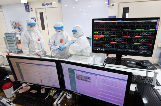 Medical professionals at the Hyemin Hospital in Gwangjin District in eastern Seoul, which specializes in treatment of Covid-19 patients, go about their duties Tuesday. Critically ill patients remained above 1,000 for the eighth consecutive day, though general coronavirus infections appear on a downward trend. [YONHAP[