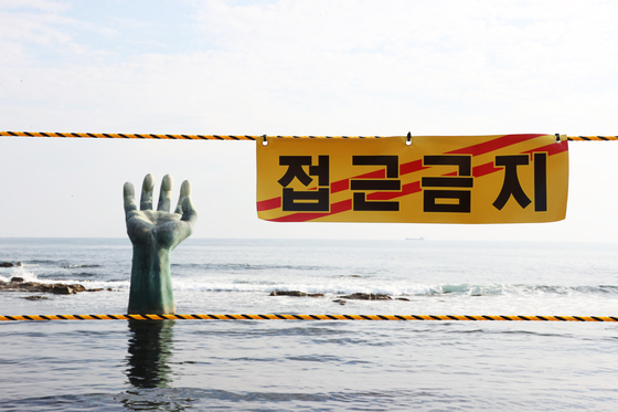An "access prohibited" sign is hung up to keep visitors away from a popular sunrise spot in Pohang, North Gyeongsang. Many people take photos of the hand-shaped sculpture as the sun rises above it. [YONHAP]