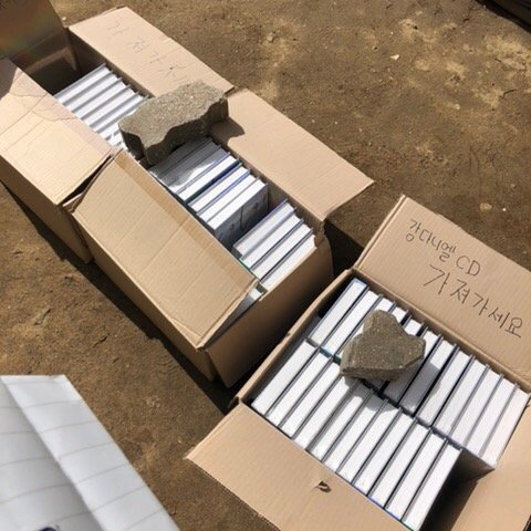 A post on an online community shows boxes of singer Kang Daniel's CDs thrown away on the street. The writing on the box reads, "Take them." [SCREEN CAPTURE]