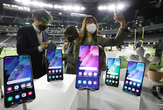 Reporters try out the Galaxy S21 Fan Edition (FE) 5G model introduced by Samsung Electronics on Tuesday, a day before the CES 2022 tech festival opens in the Las Vegas Convention Center. The new phone will be cheaper but have features similar to the company's flagship Galaxy S21. [YONHAP]