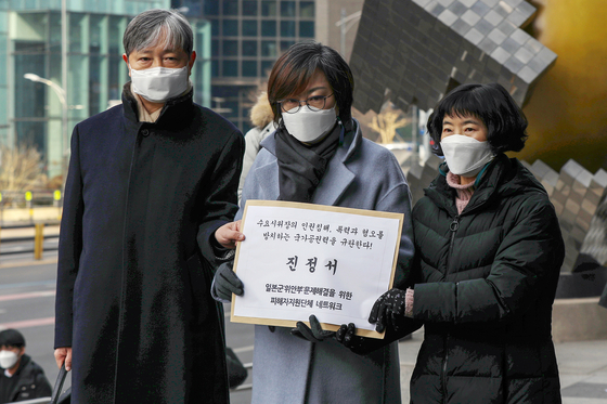 Lee Na-young, president of the Korean Council for Justice and Remembrance for the Issues of Military Sexual Slavery by Japan, center, holds up a petition submitted to the National Human Right Commission of Korea in front of the commission in central Seoul on Wednesday, requesting the commission to stop far-right groups from holding counter-rallies against the council’s weekly rallies near the Japanese Embassy in Seoul. [NEWS1]