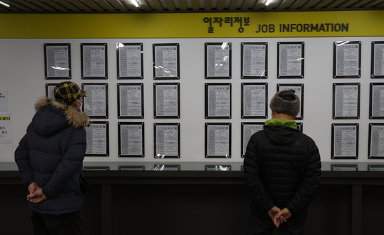 Visitors looking for job openings on a bulletin board at a job center in Seoul earlier this month. [YONHAP] 
