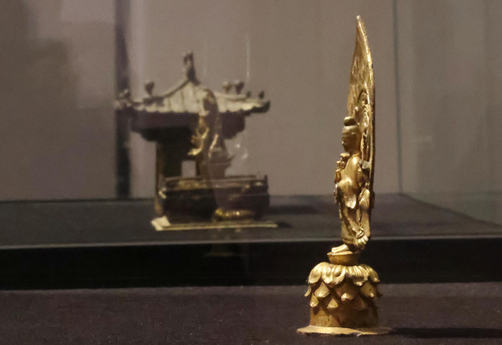 Two national treasures - the Portable Shrine of Gilt-bronze Buddha Triad, left, and the Gilt-bronze Standing Buddha Triad with Inscription of "Gyemi Year," are on display at K Auction in southern Seoul on Monday for a limited time for local reporters. The auction will take place on Jan. 27. [YONHAP]